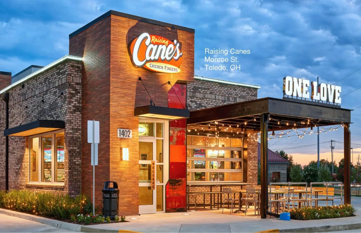 A newly built restaurant with covered outdoor seating, lit at dusk.